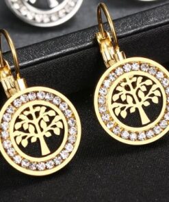 paire de boucles d'oreille en or arbre de vie sur une boite à bijoux