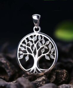 pendentif arbre de vie en argent avec pierre de zircon posé sur des graviers