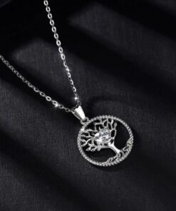 collier arbre de vie en argent avec au centre un coeur en oxyde de zirconium sur une toile noir