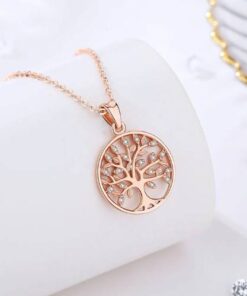 collier arbre de vie en or rose posé sur un présentoir