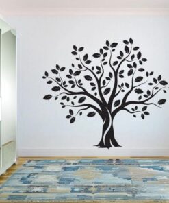 sticker arbre de vie noir avec des feuilles dans une pièce avec une commode qui à un mirroir, dans la pièce il y'a aussi un tapis design bleu sur le sol