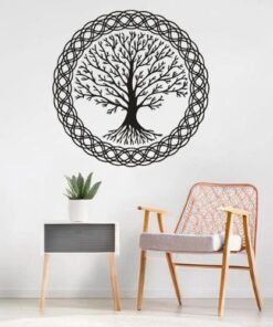 stickers viking arbre de vie noir en forme de rond dans une pèce avec une chaise en rotin et un coussin blanc, il y'a aussi une table basse avec une plante aloe vera