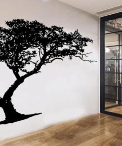 grand sticker arbre de vie noir sur un mur intérieur à côté d'une grande verrière noire