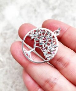 pendentif arbre de vie en argent certifié et pierre de zircon colorée dans une main