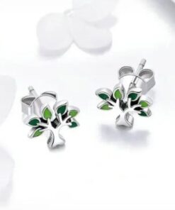 boucles d'oreilles arbre de vie en argent avec des touches de verts posé sur le sol