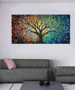 tableau arbre de vie multicolore dans un salon avec un canapé noir en tissu et une table basse noire